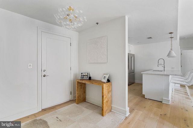 interior space with light wood-style floors, baseboards, and visible vents