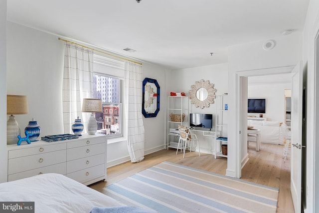 bedroom with baseboards, visible vents, and light wood-style floors