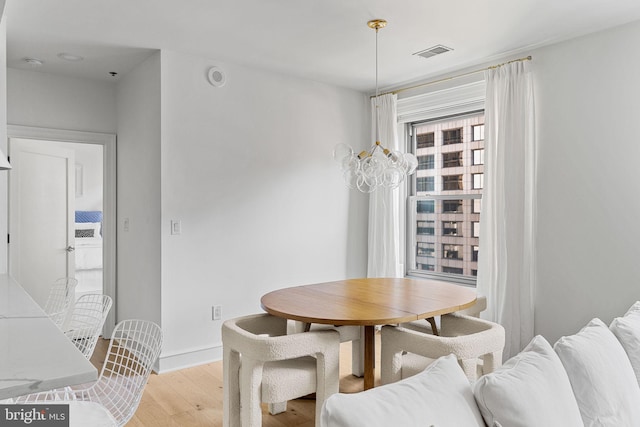 dining space featuring baseboards, visible vents, and light wood finished floors