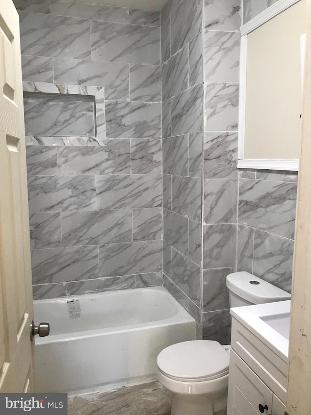 full bathroom with vanity, tiled shower / bath combo, and toilet