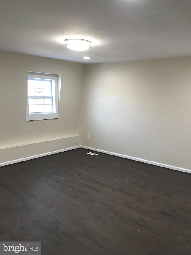 spare room featuring dark hardwood / wood-style flooring