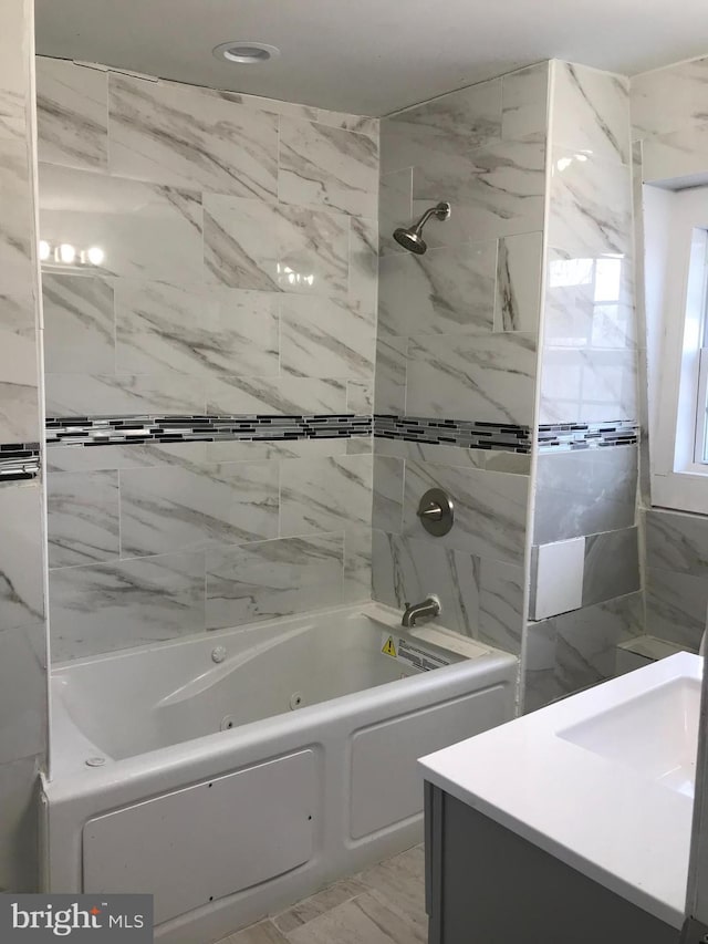 bathroom featuring tiled shower / bath and sink