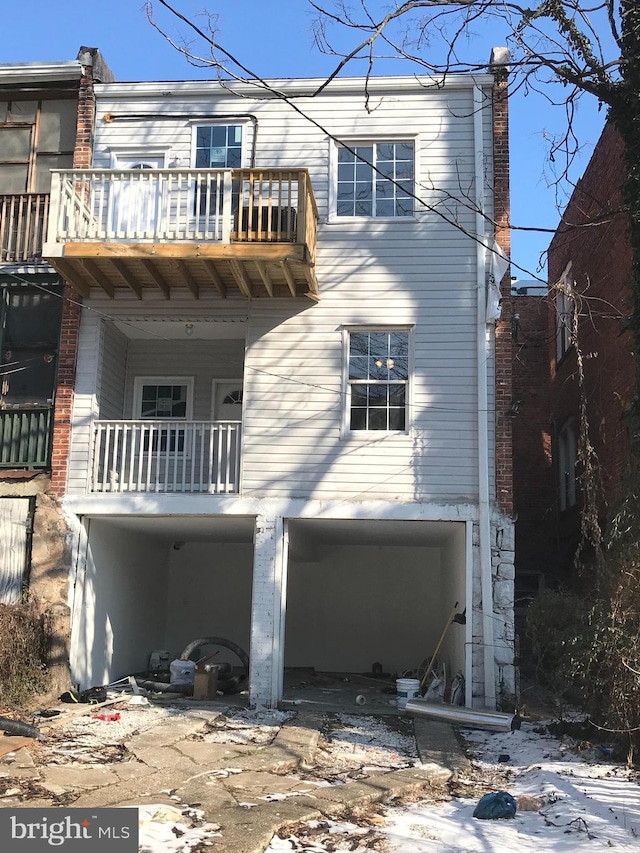 back of house featuring a garage and a balcony