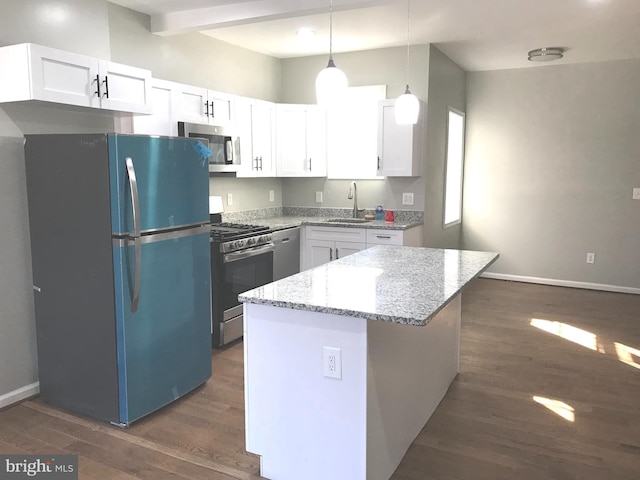 kitchen with sink, white cabinetry, light stone counters, appliances with stainless steel finishes, and pendant lighting