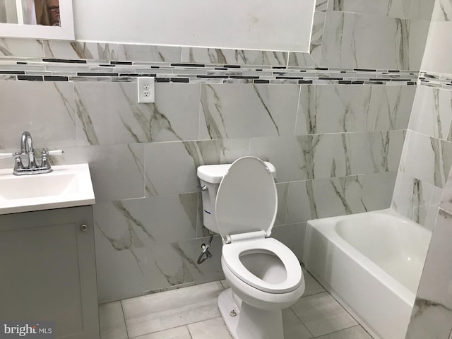 bathroom featuring tile patterned floors, vanity, toilet, and a washtub