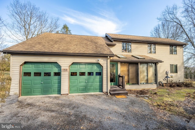 view of front of property featuring a garage and a sunroom