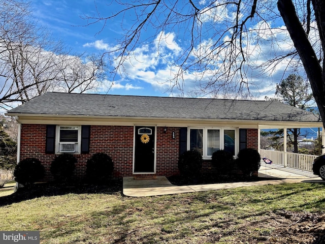 ranch-style home with a shingled roof, brick siding, fence, and a front lawn