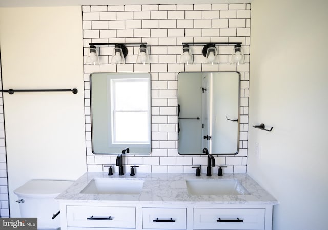 bathroom featuring tasteful backsplash, vanity, and toilet