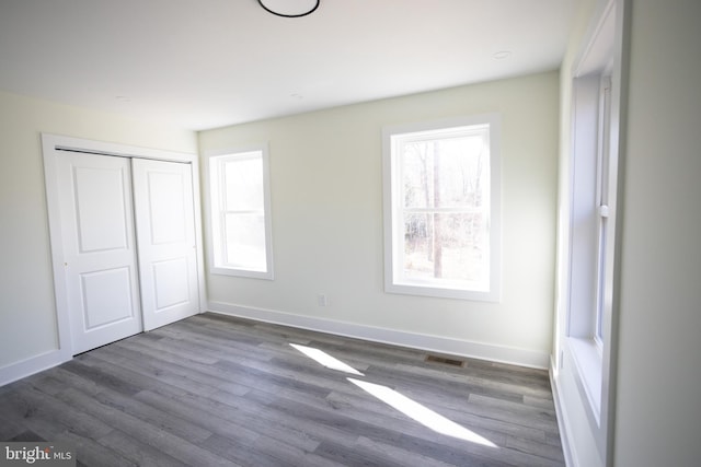 unfurnished bedroom featuring dark hardwood / wood-style flooring and a closet