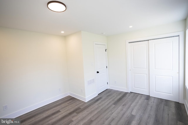 unfurnished bedroom with hardwood / wood-style floors and a closet