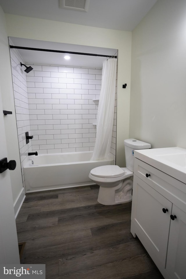 full bathroom featuring vanity, hardwood / wood-style flooring, toilet, and shower / bath combo with shower curtain