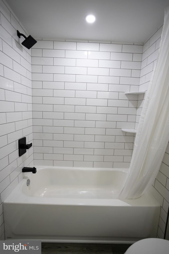 bathroom featuring shower / bath combination with curtain and toilet