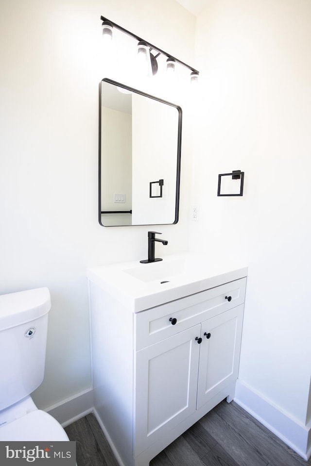 bathroom featuring hardwood / wood-style flooring, vanity, and toilet