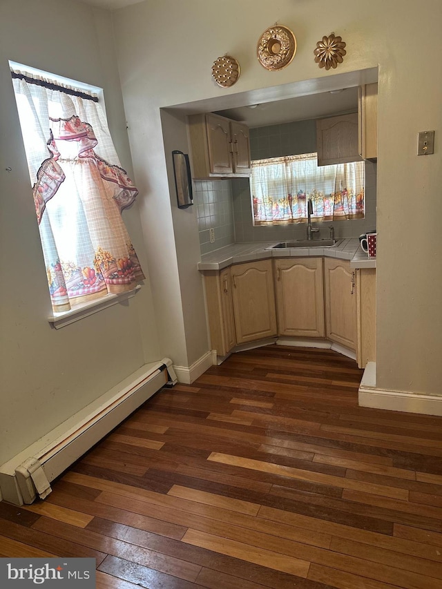 kitchen with sink, dark wood-type flooring, backsplash, light brown cabinetry, and a baseboard radiator