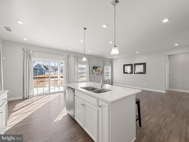 kitchen with sink, a kitchen island with sink, white cabinetry, decorative light fixtures, and stainless steel dishwasher