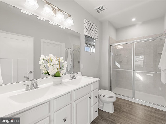 bathroom featuring vanity, toilet, an enclosed shower, and hardwood / wood-style floors