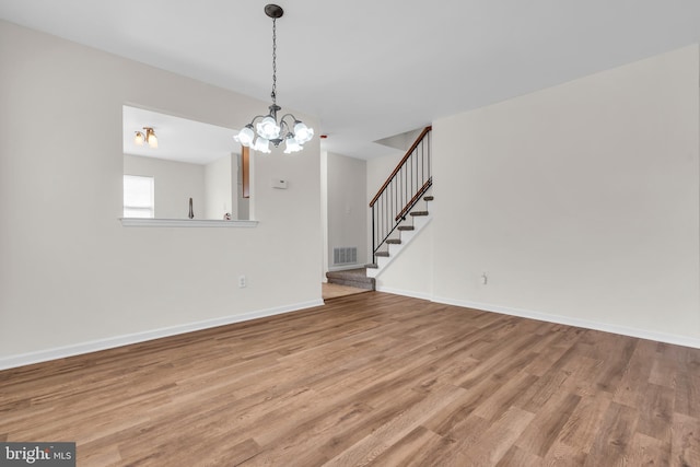 interior space with a notable chandelier and wood-type flooring