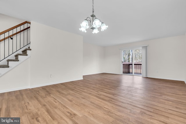 unfurnished living room with a chandelier and light hardwood / wood-style flooring