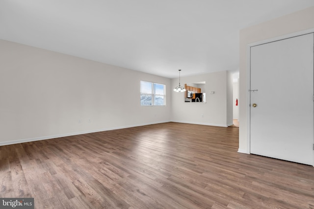 unfurnished room featuring hardwood / wood-style floors and an inviting chandelier