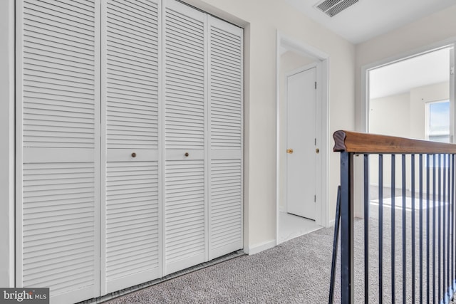 hall featuring carpet flooring