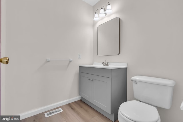 bathroom featuring hardwood / wood-style flooring, vanity, and toilet