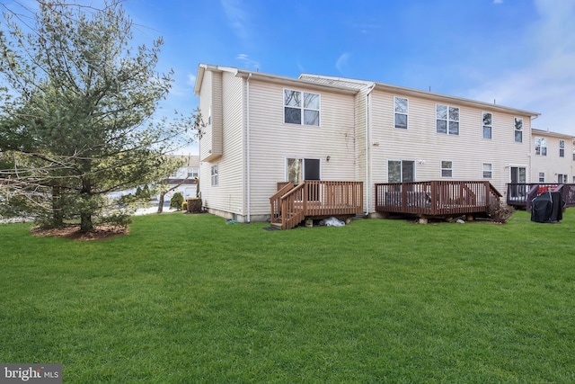 rear view of property with a wooden deck and a yard