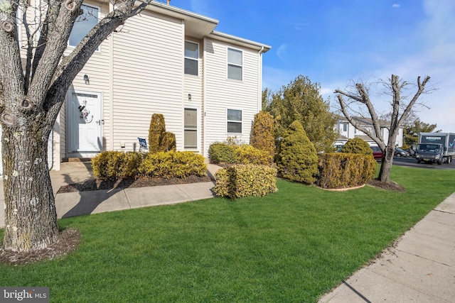 view of side of home with a yard