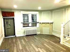 kitchen featuring dark hardwood / wood-style flooring and radiator heating unit