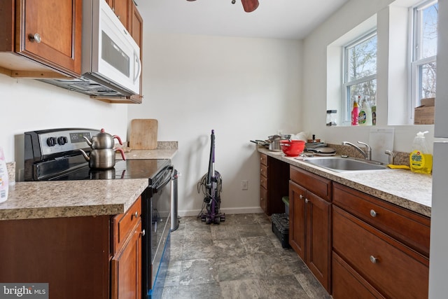 kitchen with sink, ceiling fan, and stainless steel range with electric stovetop