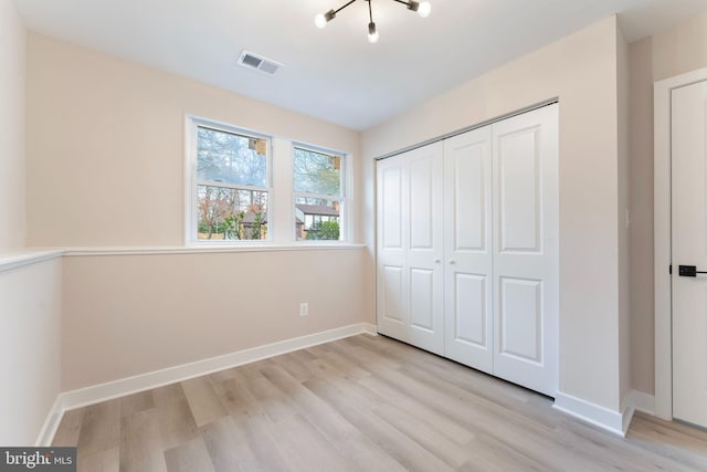 unfurnished bedroom with light hardwood / wood-style floors and a closet