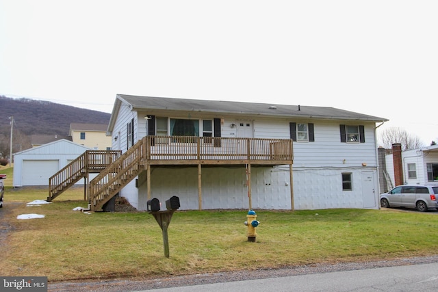 view of front of house with a garage, a deck, and a front lawn