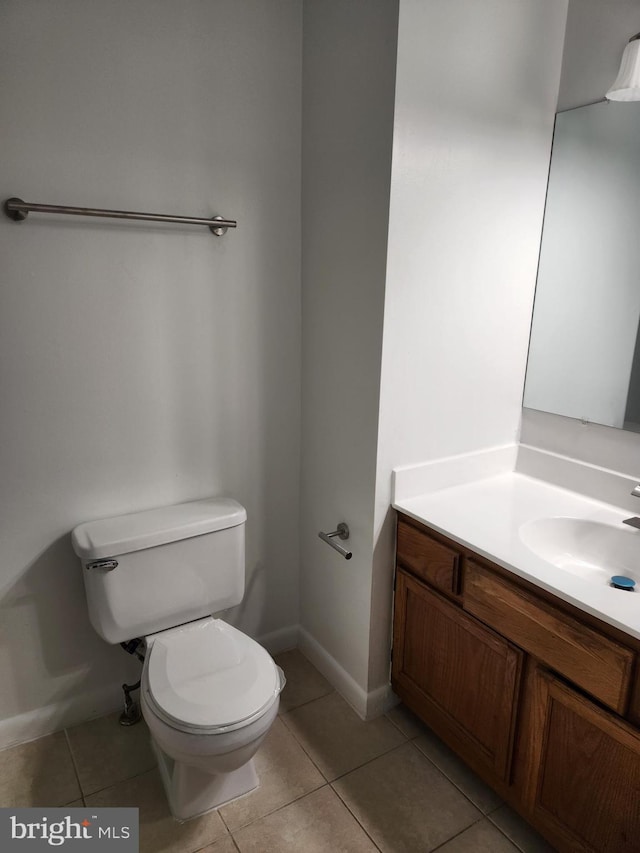 bathroom featuring vanity, tile patterned floors, and toilet