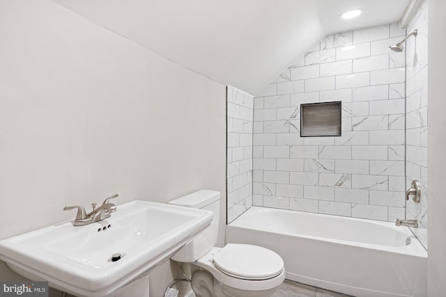 full bathroom with sink, toilet, lofted ceiling, and tiled shower / bath combo