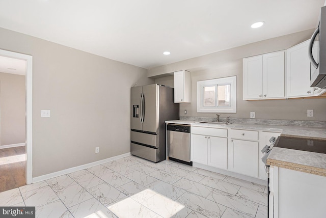 kitchen featuring white cabinets, appliances with stainless steel finishes, and sink