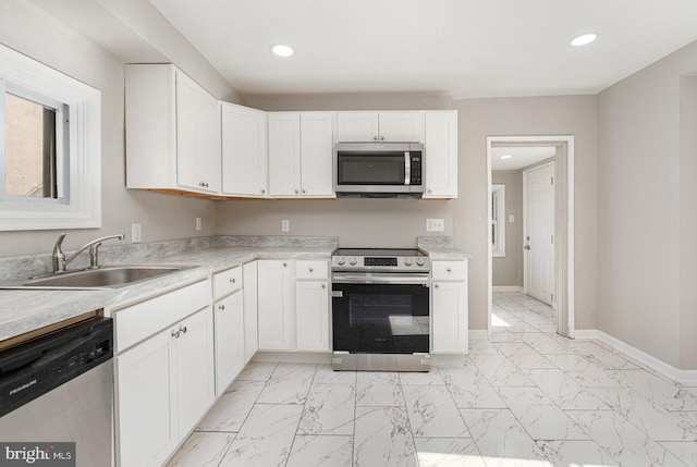 kitchen featuring white cabinets, stainless steel appliances, and sink