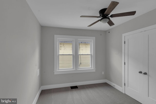 unfurnished room featuring ceiling fan and carpet