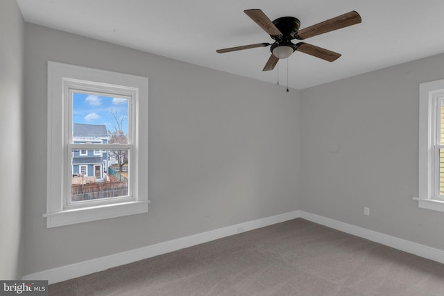 carpeted spare room featuring ceiling fan