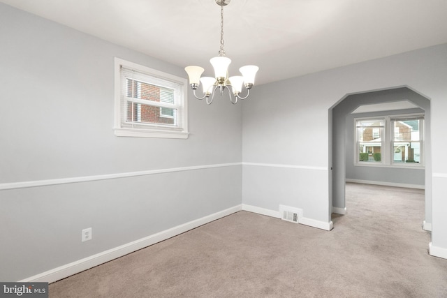 spare room with light carpet, baseboards, visible vents, and a wealth of natural light