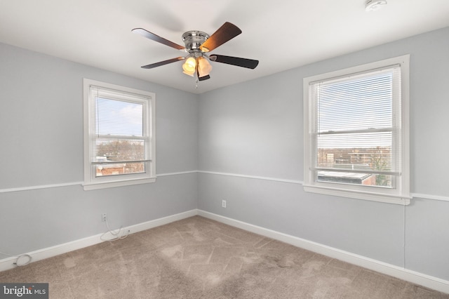 unfurnished room featuring light carpet, baseboards, and a ceiling fan