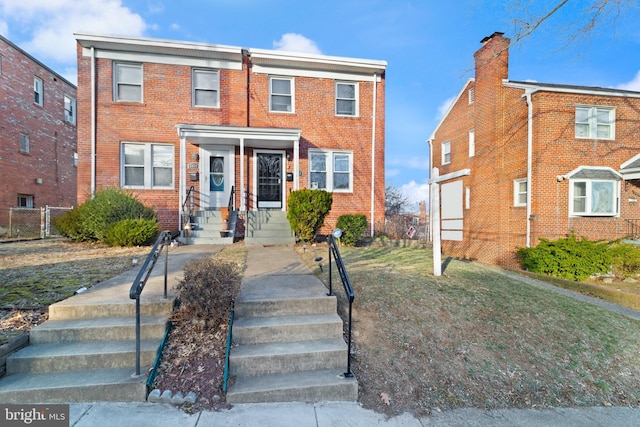 view of property with brick siding and a front yard