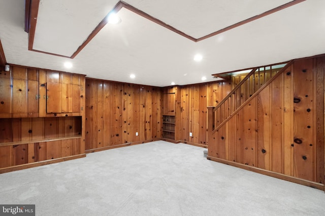 finished below grade area with wooden walls, light carpet, recessed lighting, baseboards, and stairs