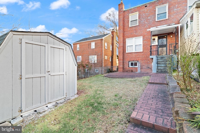 view of yard with fence, an outdoor structure, and a shed