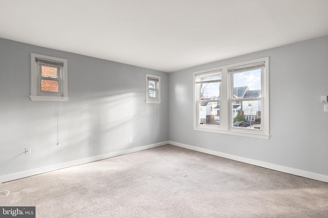 carpeted spare room featuring baseboards