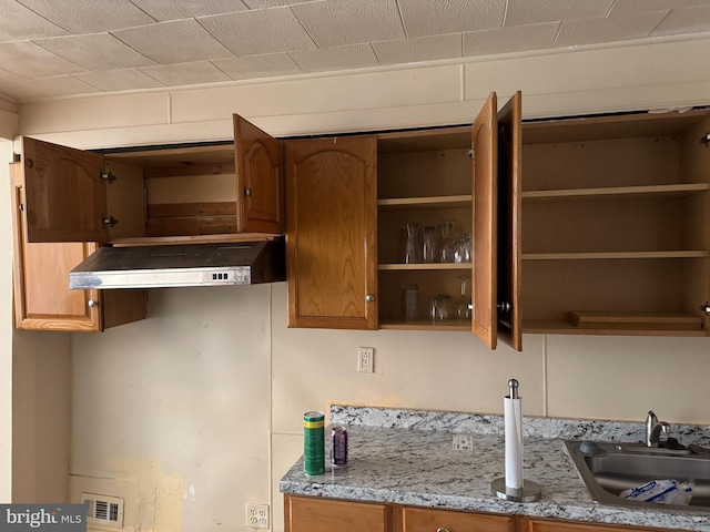 kitchen with light stone counters and sink