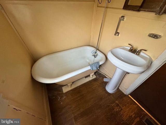 bathroom featuring sink, a bathtub, and hardwood / wood-style floors