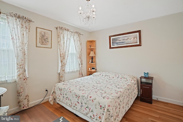 bedroom featuring wood-type flooring and a notable chandelier