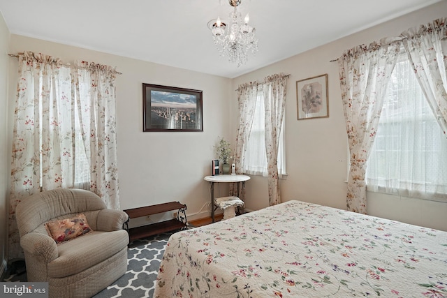 bedroom featuring an inviting chandelier and dark hardwood / wood-style flooring