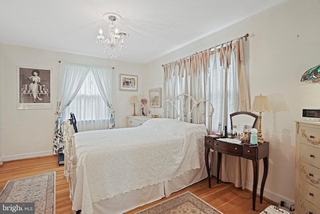 bedroom with an inviting chandelier and light wood-type flooring