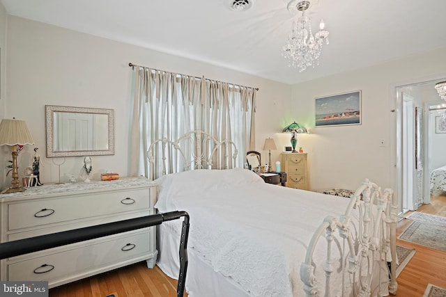 bedroom featuring a chandelier and light wood-type flooring