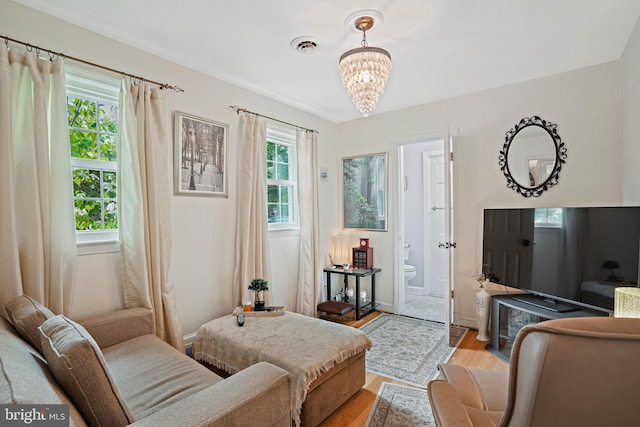 sitting room with an inviting chandelier and light hardwood / wood-style floors